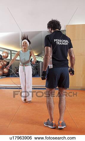 Woman working with trainer in gym View Large Photo Image Stock Photograph - Woman working with trainer in gym. Fotosearch