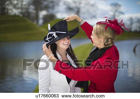 Women adjusting decorative hats View Large Photo Image Stock Image - Women adjusting decorative hats. Fotosearch