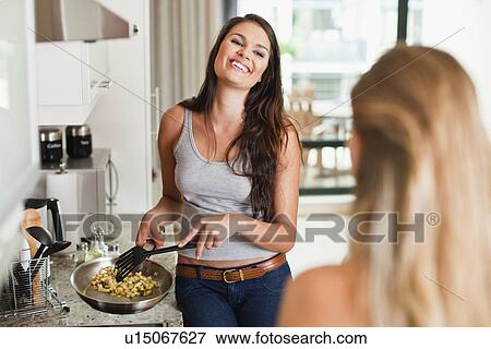 Stock Photo - Women cooking together in kitchen. Fotosearch