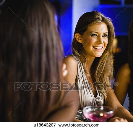 Women having drinks together at bar View Large Photo Image Stock Photo - Women having drinks together at bar. Fotosearch