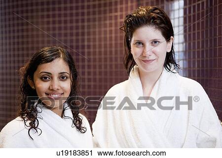 Stock Image - Women in bathrobes smiling in shower. Fotosearch