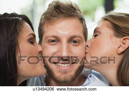 Women kissing smiling mans cheeks View Large Photo Image Stock Photograph - Women kissing smiling mans cheeks. Fotosearch