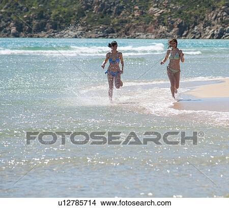 Women running in waves on beach View Large Photo Image Picture - Women running in waves on beach. Fotosearch
