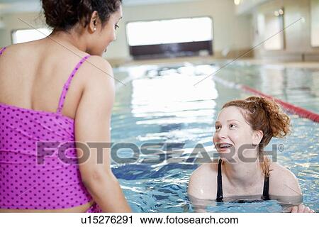 Stock Image - Women swimming in indoor pool. Fotosearch