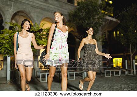 Women walking on city street at night View Large Photo Image Stock Photo - Women walking on city street at night. Fotosearch