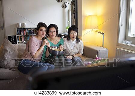 Stock Photo - Women watching scary movie together. Fotosearch