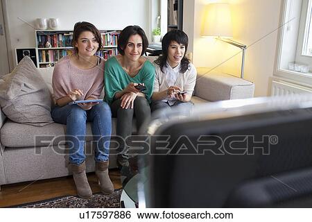Stock Photograph - Women watching television together. Fotosearch