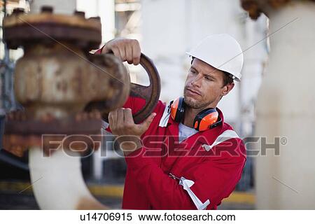 Worker adjusting gauge at chemical plant View Large Photo Image Stock Photography - Worker adjusting gauge at chemical plant. Fotosearch