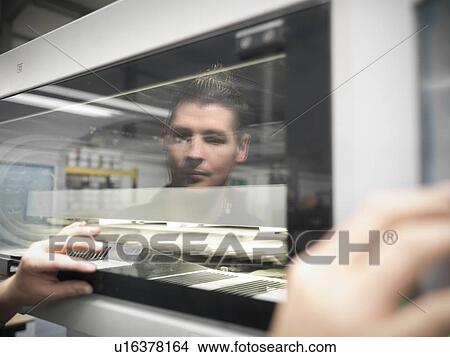 Picture - Worker checking levels of printing press. Fotosearch