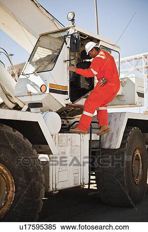 Worker climbing crane at oil refinery View Large Photo Image Stock Photography - Worker climbing crane at oil refinery. Fotosearch