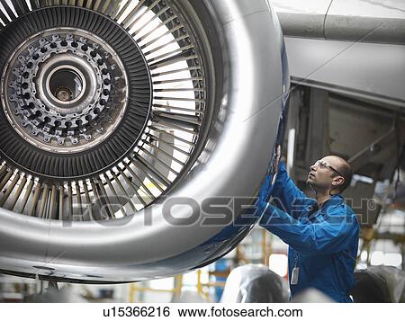Worker examining airplane engine View Large Photo Image Stock Photograph - Worker examining airplane engine. Fotosearch