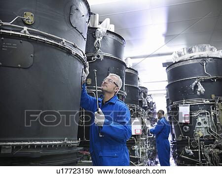 Worker examining machinery on drums View Large Photo Image Stock Image - Worker examining machinery on drums. Fotosearch