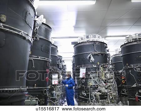 Stock Photo - Worker examining machinery on drums. Fotosearch