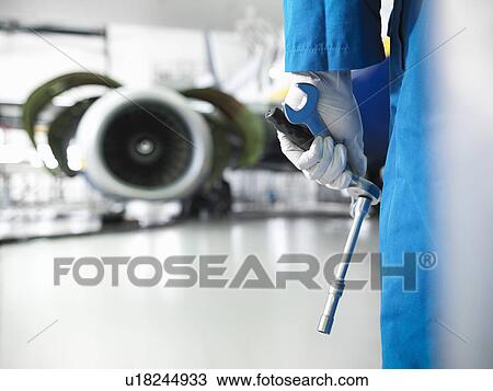 Worker holding tools in airport hangar View Large Photo Image Stock Image - Worker holding tools in airport hangar. Fotosearch