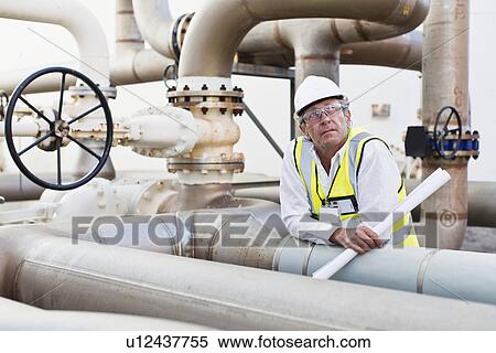 Stock Photography - Worker on pipes at chemical plant. Fotosearch