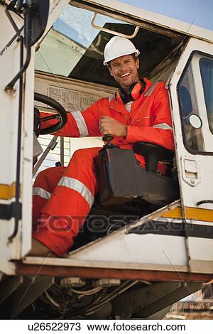 Worker operating crane at oil refinery View Large Photo Image Stock Image - Worker operating crane at oil refinery. Fotosearch