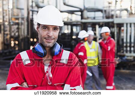 Stock Photo - Worker standing at chemical plant. Fotosearch