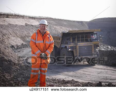 Stock Image - Worker standing at coal mine. Fotosearch