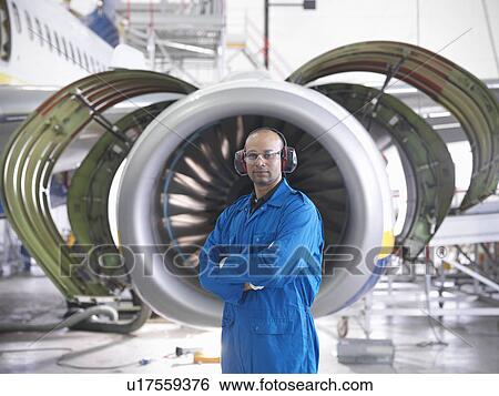 Worker standing by airplane engine View Large Photo Image Stock Photograph - Worker standing by airplane engine. Fotosearch
