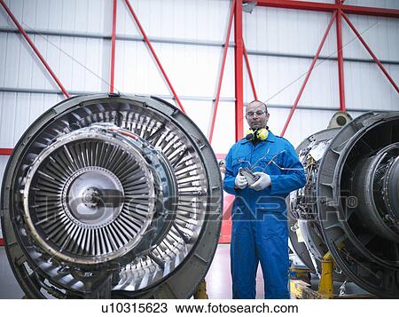 Worker standing by airplane engines View Large Photo Image Stock Image - Worker standing by airplane engines. Fotosearch