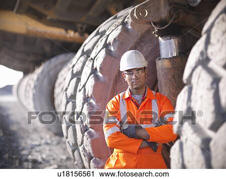 Worker standing by trucks in coal mine View Large Photo Image Stock Image - Worker standing by trucks in coal mine. Fotosearch