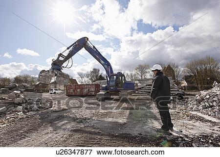 Worker standing on construction site View Large Photo Image Stock Photo - Worker standing on construction site. Fotosearch