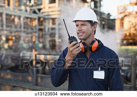 Worker using walkie talkie on site View Large Photo Image Picture - Worker using walkie talkie on site. Fotosearch