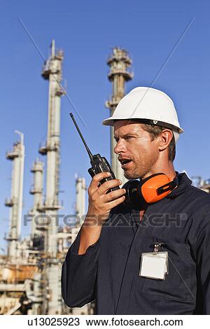 Stock Image - Worker using walkie talkie on site. Fotosearch