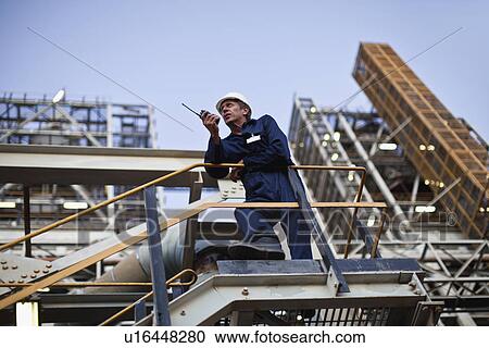 Worker using walkie talkie on site View Large Photo Image Stock Image - Worker using walkie talkie on site. Fotosearch