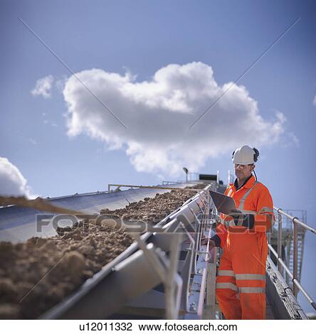 Worker with clipboard by conveyor belt View Large Photo Image Stock Image - Worker with clipboard by conveyor belt. Fotosearch