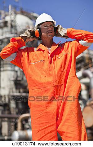 Worker with earphones at oil refinery View Large Photo Image Picture - Worker with earphones at oil refinery. Fotosearch
