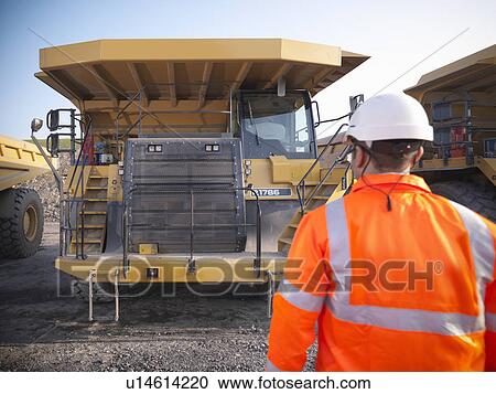 Stock Image - Worker with equipment in coal mine. Fotosearch
