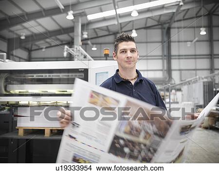 Picture - Worker with paper in printers shop. Fotosearch