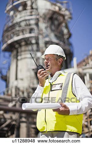 Worker with walkie talkie on site View Large Photo Image Stock Photo - Worker with walkie talkie on site. Fotosearch