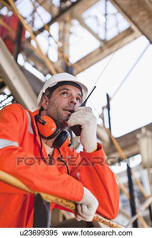 Worker with walkie talkie on site View Large Photo Image Stock Photography - Worker with walkie talkie on site. Fotosearch