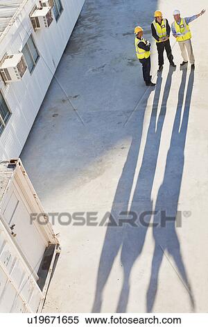 Stock Photography - Workers casting shadows on site. Fotosearch