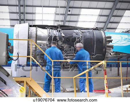 Workers examining airplane machinery View Large Photo Image Picture - Workers examining airplane machinery. Fotosearch
