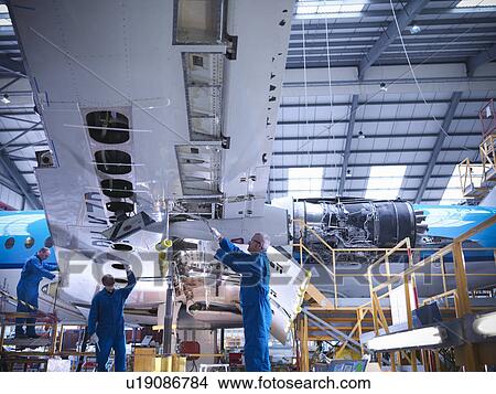 Workers examining airplane machinery View Large Photo Image Picture - Workers examining airplane machinery. Fotosearch