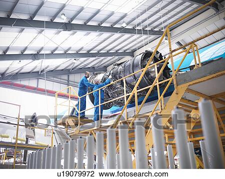 Workers examining airplane machinery View Large Photo Image Stock Image - Workers examining airplane machinery. Fotosearch