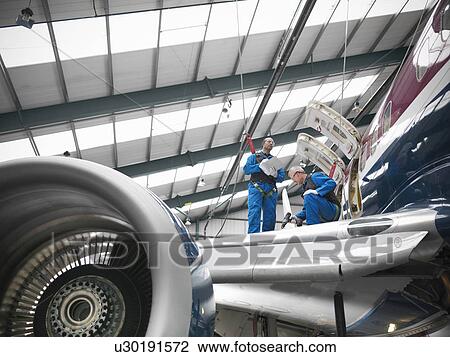 Workers examining airplane wing View Large Photo Image Stock Image - Workers examining airplane wing. Fotosearch