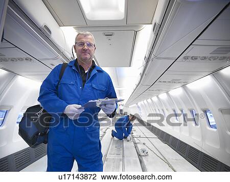 Stock Image - Workers in empty airplane. Fotosearch