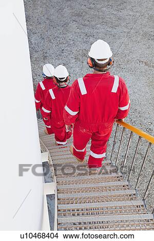 Picture - Workers on steps at chemical plant. Fotosearch