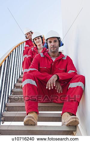 Stock Image - Workers on steps at chemical plant. Fotosearch