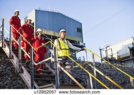 Stock Photo - Workers on steps at chemical plant. Fotosearch