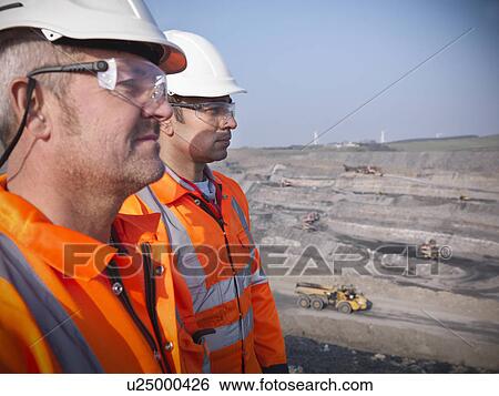Stock Photograph - Workers overlooking coal mine. Fotosearch