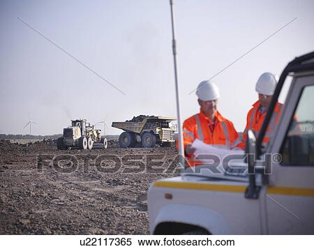 Workers reading blueprints at coal mine View Large Photo Image Stock Photography - Workers reading blueprints at coal mine. Fotosearch