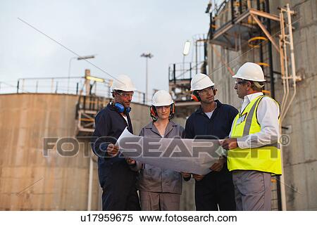 Stock Photography - Workers reading blueprints at plant. Fotosearch