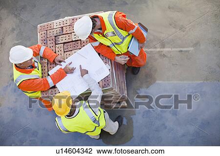 Workers reading blueprints on site View Large Photo Image Stock Image - Workers reading blueprints on site. Fotosearch