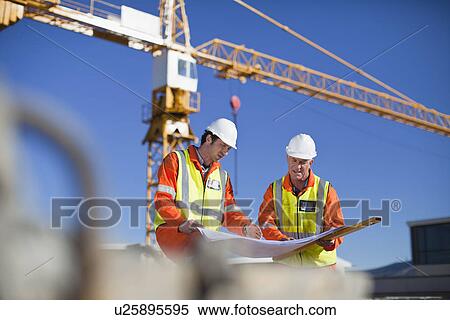 Workers reading blueprints on site View Large Photo Image Stock Photography - Workers reading blueprints on site. Fotosearch