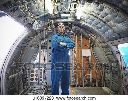 Stock Image - Workers standing in empty airplane. Fotosearch